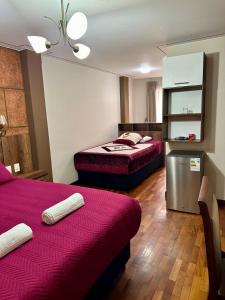 a hotel room with two beds and a refrigerator at Esmeralda con altura in Callampaya +65 photos
