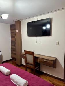 a room with a bed and a tv on a wall at Esmeralda con altura in Callampaya