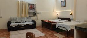a room with two beds and a chair in it at Niyati homestay in Varanasi