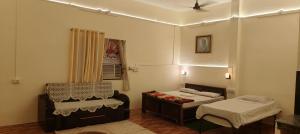 a room with two beds and a chair in it at Niyati homestay in Varanasi