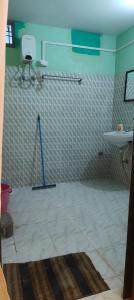 a bathroom with a white tile floor and a sink at Niyati homestay in Varanasi