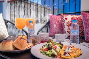a table with a plate of food and bread and drinks at Riad el Fenna 1974 in Chefchaouen
