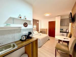 a room with a bed and a kitchen with a sink at Alteagroup Joy in Altea