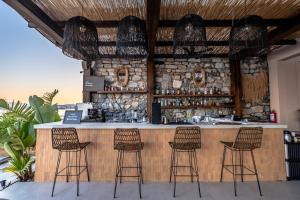 Eine Bar mit Hockern vor einer Steinmauer in der Unterkunft İsolina Bodrum in Bodrum City