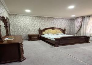 a bedroom with a bed and a dresser and a desk at Marshall in Termiz +7 photos