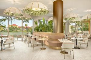a restaurant with tables and chairs and chandeliers at ONE GT Grand Cayman in George Town