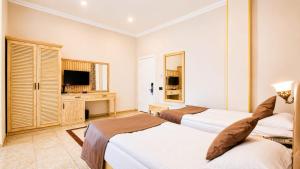 a hotel room with two beds and a television at Ruma Qala Hotel in Sheki