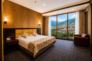 a hotel room with a bed and a large window at Ruma Qala Hotel in Sheki