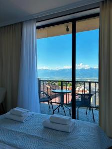 a bedroom with a bed and a balcony with a view at Horizont Boutique Hotel in Telavi