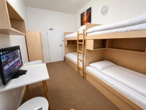 a room with bunk beds and a desk with a computer at Bel Hostel in Tatranská Lomnica