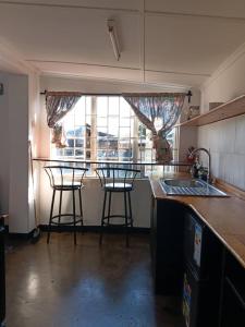 a kitchen with two bar stools and a counter top at Ntinti Stays Cottage in Ndola