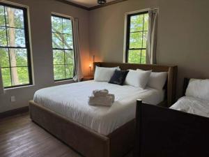 a bedroom with a large bed and two windows at Maison Foxglove - Petite Acres Chateau in New Buffalo