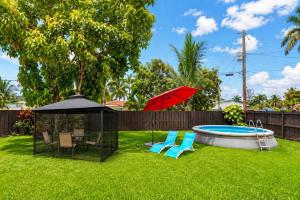 a yard with a gazebo and chairs and a pool at The Golfstream Dunes Villa in Hallandale Beach