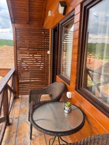 a patio with a table and chairs on a balcony at Rtanjska kućica in Boljevac