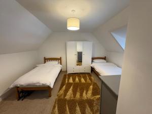 a attic bedroom with two beds and a mirror at The townhouse in Stornoway