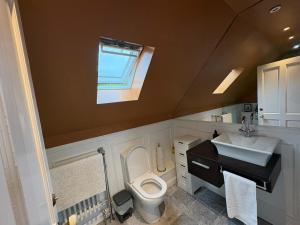 a bathroom with a toilet and a sink and a window at The townhouse in Stornoway +4 photos