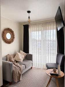 a living room with a couch and a window at Studios y Departamentos Nómades del Lago in Puerto Varas