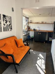 an orange bed in a room with a kitchen at Ntinti Stays Cottage in Ndola