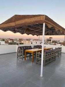 a table and chairs under an umbrella on a roof at pure peace hotel in Luxor