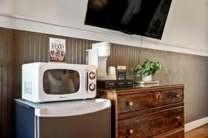 a microwave sitting on top of a refrigerator next to a dresser at Historic Riverview Inn Five in Chattanooga