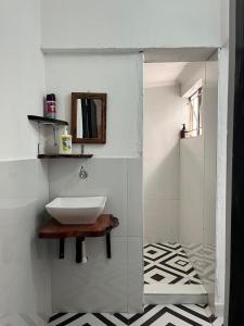 a white bathroom with a sink and a mirror at Ntinti Stays Cottage in Ndola