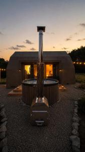 a building with a hot tub in front of a house at Bunkier House in Niedźwiada