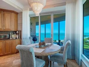 a dining room with a table and chairs and windows at Beachfront Elegance Escape in Naples