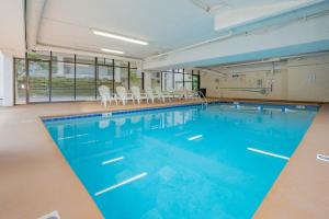 a large swimming pool with blue water in a building at Oak Square Rentals in Gatlinburg
