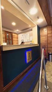 a lobby with a blue wall with a sign on it at Hotel Villa Rica in Rio de Janeiro