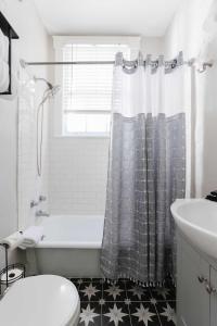 a bathroom with a tub and a toilet and a sink at Oglethorpe Square Historic Apt Central & Walkable in Savannah