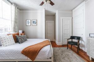 a bedroom with a bed and a black chair at Oglethorpe Square Historic Apt Central & Walkable in Savannah +51 photos