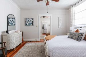 a bedroom with a bed and a ceiling fan at Oglethorpe Square Historic Apt Central & Walkable in Savannah