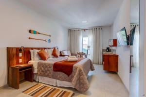 a bedroom with a large bed and a table at Cairé Suites in Itacaré +23 photos