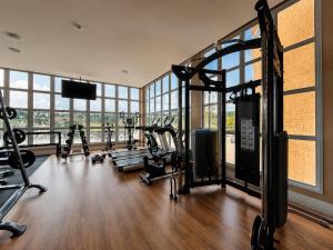 a gym with several tread machines in a room with windows at Castelos do Vale by Livá OFICIAL in Bento Gonçalves
