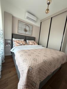 a bedroom with a large bed with a comforter at Harbour Light Residence in Bjeliši
