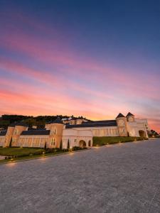 a large building with a sunset in the background at Castelos do Vale by Livá OFICIAL in Bento Gonçalves