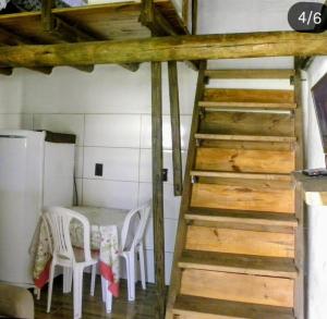 a staircase in a room with a table and chairs at ICE POINT SURF HOUSES Praia do Rosa- Necessário Pré-pagamento Metade Valor Total in Praia do Rosa