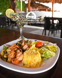 a plate of shrimp rice and vegetables and a glass at Villas & Suites Santa Monica in Rincon de Guayabitos