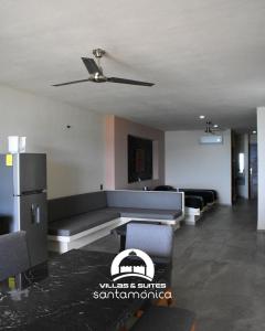 a living room with a couch and a ceiling fan at Villas & Suites Santa Monica in Rincon de Guayabitos
