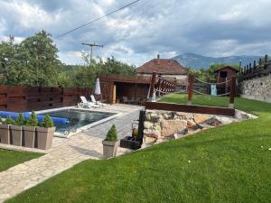 a backyard with a swimming pool and a lawn at Rtanjska kućica in Boljevac