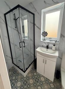 a bathroom with a glass shower and a sink at The Hide at St Andrews in Fife