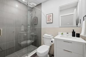 a bathroom with a shower and a toilet and a sink at Rare 3BR Gem Mini Putt Terrace & CN Tower Views in Toronto
