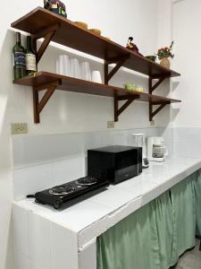 a kitchen with a counter top with a microwave at Lu House in Flores