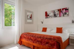 a white bedroom with a bed with an orange blanket at Hotel Daniele in Lignano Sabbiadoro +170 photos