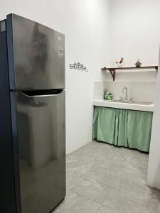 a refrigerator in a kitchen with a sink at Lu House in Flores +6 photos