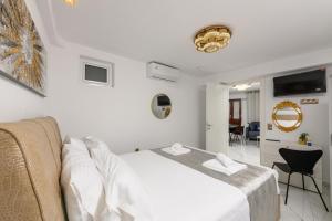 a white bedroom with a bed and a couch at Villa Andriana in Panagia