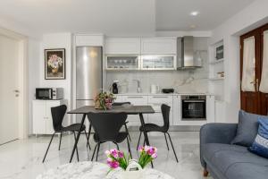 a kitchen and living room with a table and chairs at Villa Andriana in Panagia