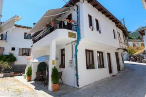 a white building with a balcony and plants at Villa Andriana in Panagia