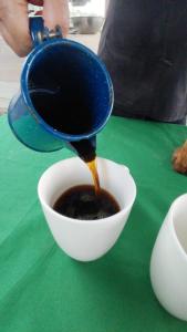a person pouring coffee into a bowl on a table at Villa Terraza in El Castillo de La Fortuna
