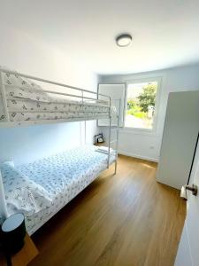 a bedroom with a bunk bed and a window at Casa Cachú in Baiona